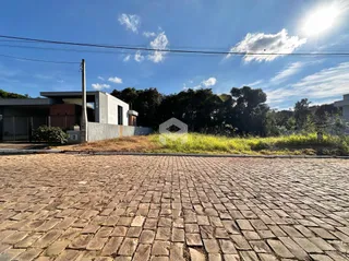 Vista da fachada de uma residência em Lajeado, Brasil, com área pavimentada na frente.