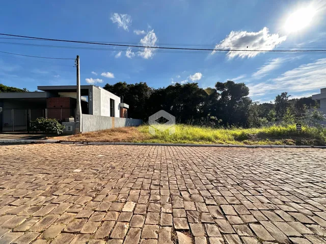 Vista da fachada de uma residência em Lajeado, Brasil, com área pavimentada na frente.