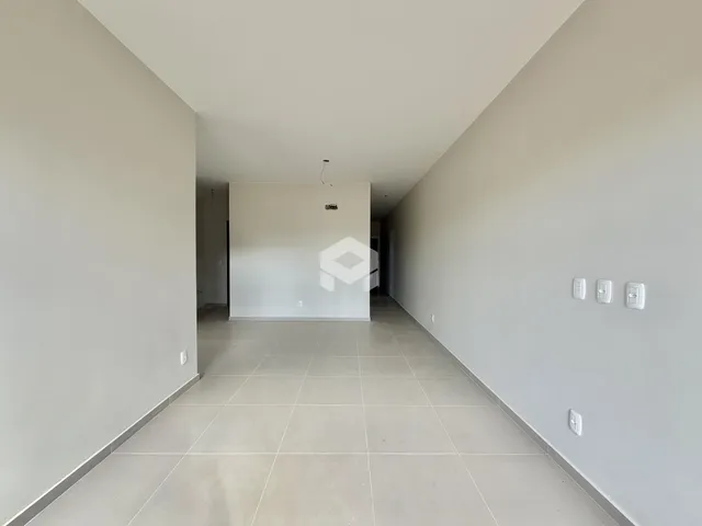 Hall de corredor com piso de cerâmica claro.