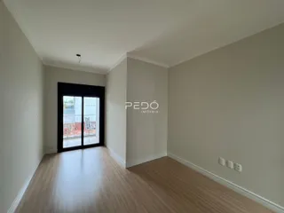 Corredor interno com piso de madeira e porta de vidro.