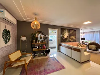 Sala de estar iluminada com sofá e decoração em um imóvel no Brasil.