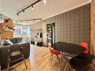 Sala de estar com piso de madeira e mesa de jantar em um imóvel no Brasil.