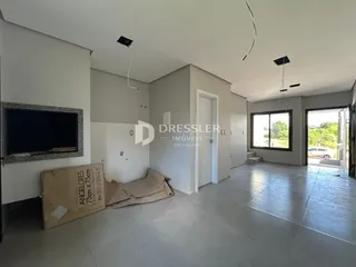 Sala de estar com piso de cerâmica e paredes brancas em um imóvel.