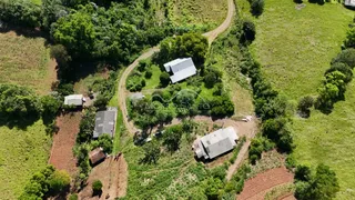 Vista aérea de uma propriedade rural com campos e estruturas rurais.