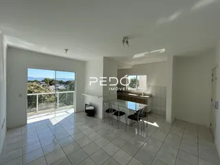 Sala de estar com piso de cerâmica e porta de vidro abrindo para o exterior.