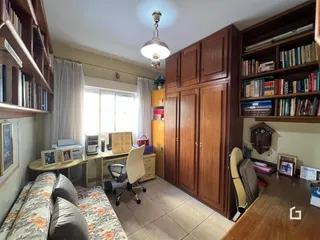 Sala de estar com móveis de madeira e janela grande em um imóvel no Brasil.