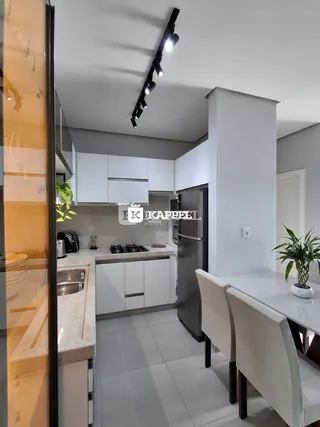 Uma cozinha moderna com armários brancos e eletrodomésticos de aço inoxidável.