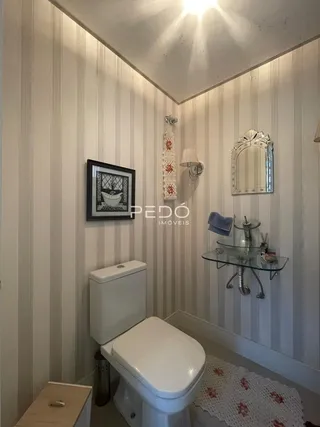 Foto de um banheiro interno com vaso sanitário branco e revestimento de parede.