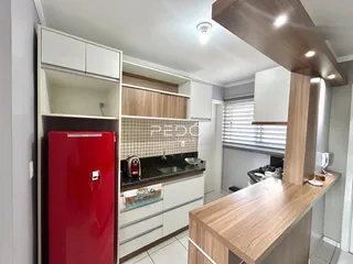 Cozinha moderna com armários brancos e bancada escura.