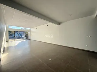 Vista interna de uma sala ampla com piso de cerâmica.