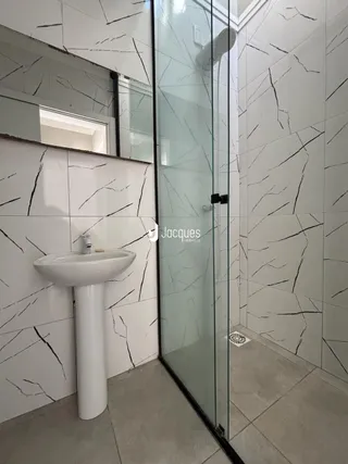 Interior de um banheiro com revestimento de parede em mármore preto e branco.