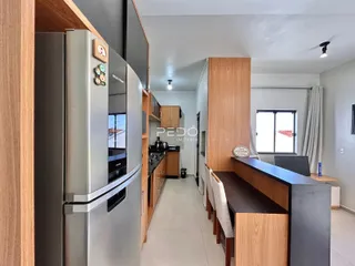 Vista da cozinha e área de jantar com armários de madeira e eletrodomésticos em Lajeado.
