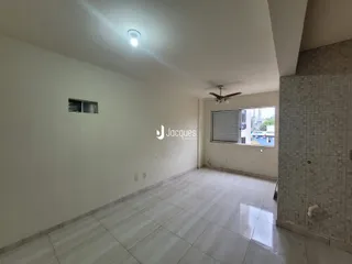 Interior de um corredor com paredes brancas e piso de cerâmica claro.
