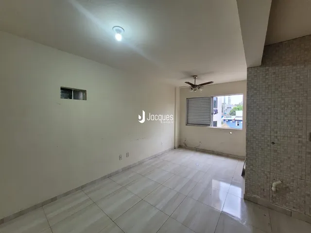 Interior de um corredor com paredes brancas e piso de cerâmica claro.