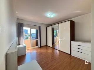 Sala de estar com piso de madeira e portas de vidro.