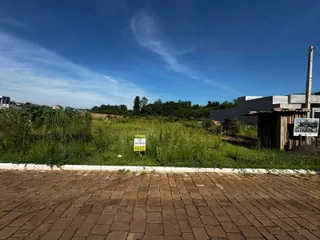 Vista externa da propriedade com gramado e vegetação ao fundo.