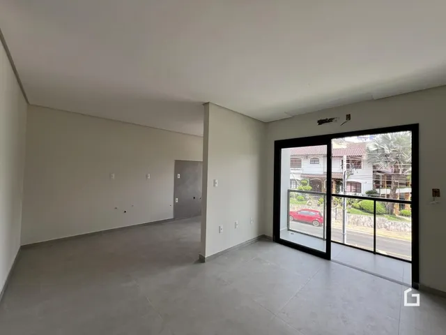 Ambiente interno de uma sala ampla com piso de concreto.