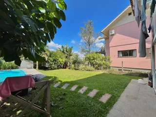 Vista externa de uma casa com quintal e piscina.