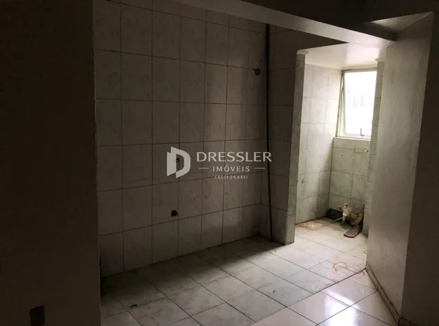 Hall de entrada com paredes brancas e piso de cerâmica.