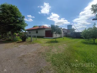 Fachada de uma casa residencial com telhado vermelho e área gramada.