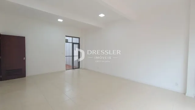 Ambiente interno amplo com paredes brancas e piso claro.