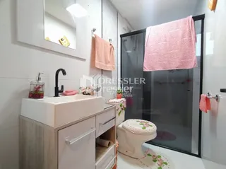 Foto de um banheiro com pia e box de vidro.