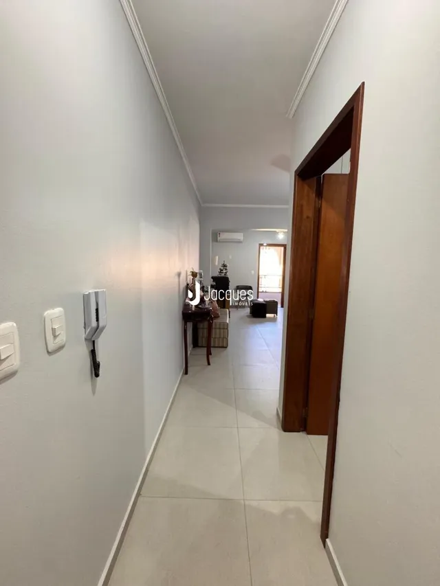 Corredor interno de uma residência com paredes brancas.