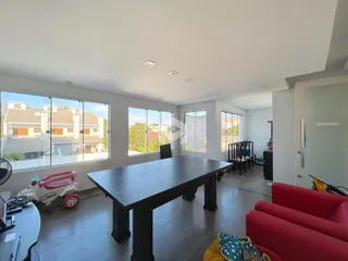 Sala de estar com grandes janelas que dão vista para outras construções.