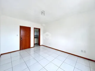 Vista interna de um ambiente com piso de cerâmica branca e portas de madeira.