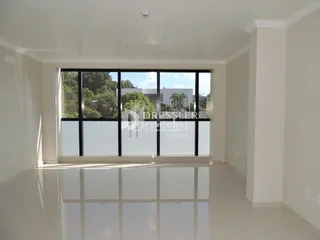 Sala interna com grandes janelas que oferecem vista para o exterior.