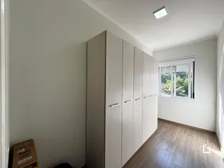 Um corredor interno com armários embutidos e piso de madeira.