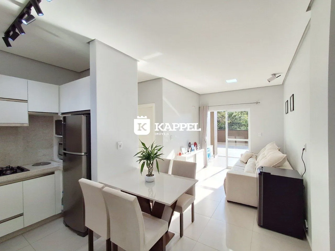 Ambiente interno com cozinha e sala de jantar em um apartamento moderno.
