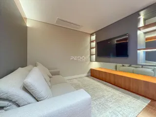 Sala de estar moderna com sofá claro e painel de madeira.