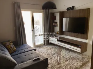 Sala de estar com sofá e janelas de vidro.
