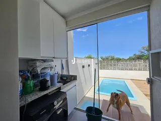 Vista da cozinha com acesso a uma área externa com piscina.