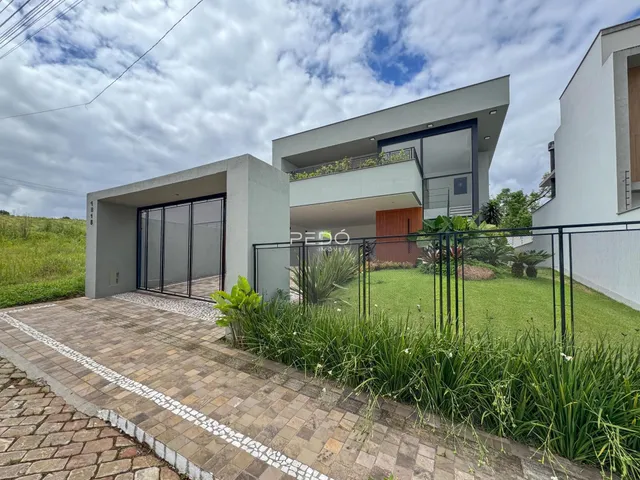 Fachada de uma casa moderna com jardim e cerca em Lajeado, Brasil.