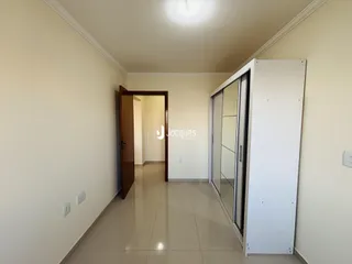 Corredor interno de uma residência com piso de cerâmica clara.