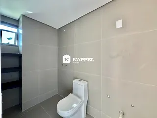 Este é um banheiro com revestimento em tons de cinza claro e um vaso sanitário branco.