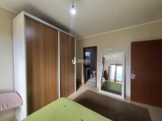 Quarto com armário de madeira e porta de entrada em um imóvel em Lajeado.