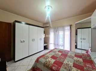 Quarto com armários embutidos e cama de casal.