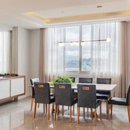 Sala de estar com grandes janelas que oferecem uma vista da paisagem urbana.
