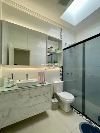 Foto de um banheiro moderno com box de vidro e bancada de mármore.