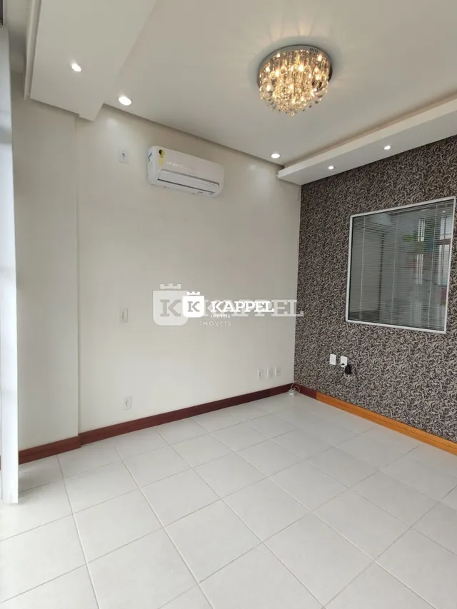 Uma sala de estar com piso de cerâmica branca e parede texturizada cinza.