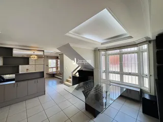 Sala de estar com piso de cerâmica e grandes janelas.