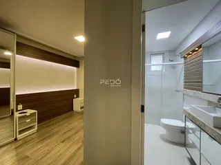 Corredor interno com piso de madeira e acabamentos modernos.