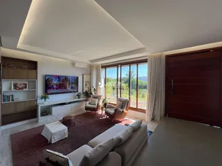 Sala de estar moderna com sofá e decoração em madeira.