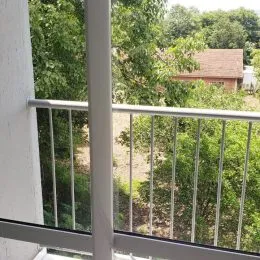 Vista externa de um terraço com vegetação densa.