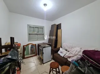 Interior de um quarto com cama e guarda-roupa de madeira.