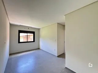 Vista interna de um ambiente com paredes brancas e piso claro.