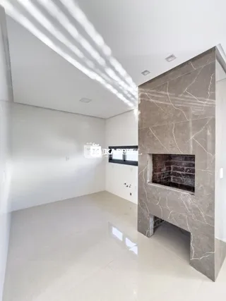 Ambiente interno amplo com paredes brancas e piso claro.